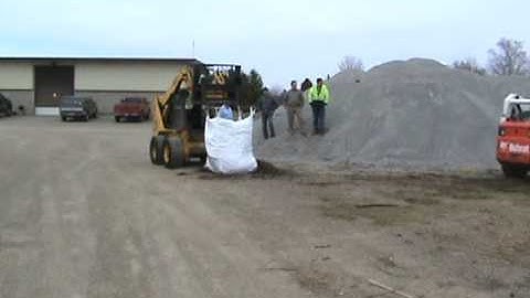 Bobcat S300 loading tree stumps into Load a Bag