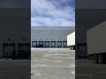 “Tractor trailer docking in gigantic yard, full view.”