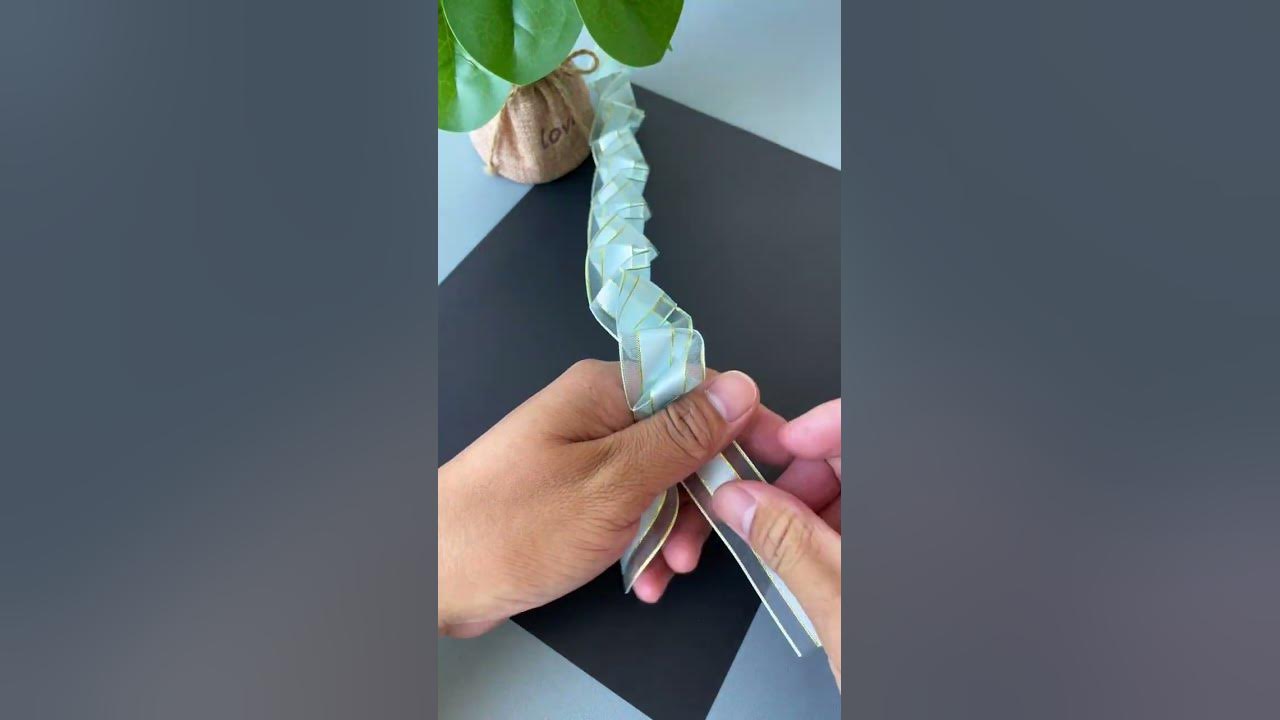 A ribbon is folded and pulled to become a beautiful rose flower. DIY handmade kindergarten handm A ribbon is folded and pulled to become a beautiful rose flower. DIY handmade kindergarten handm