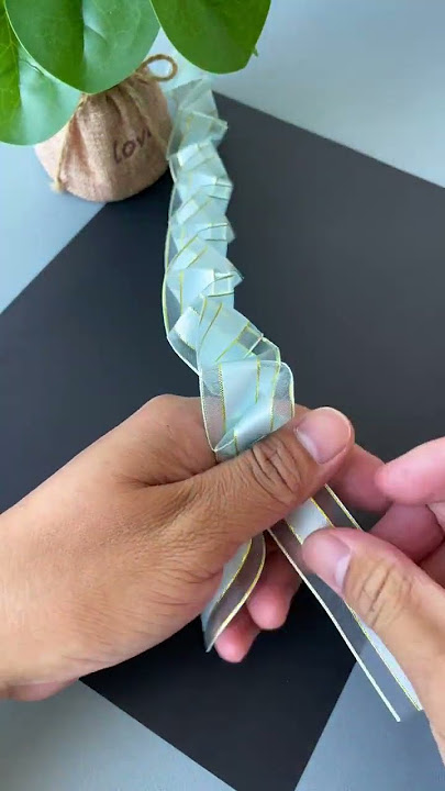A ribbon is folded and pulled to become a beautiful rose flower. DIY handmade kindergarten handm