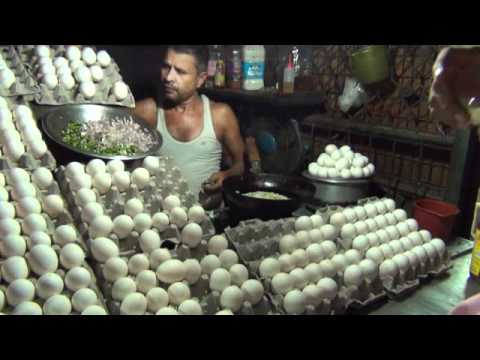 Man Cooking Egg Omelette And Giving It To Customer On Bread-11-08-2015