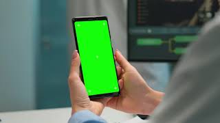 Scientist fiddling with cellphone with green screen  - Chroma Key - No Copyright