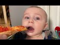 Baby trying pizza for the first time