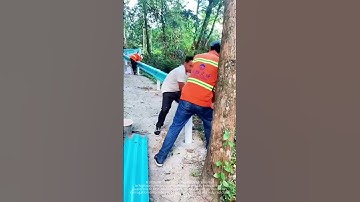 The process of installing the corrugated guardrail by the worker
