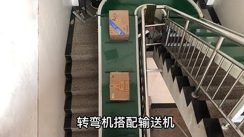 Inclined belt conveyor carries cartons upstairs