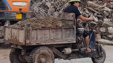 Công nông ba bánh và ô tô tải chở vật liệu xây dựng