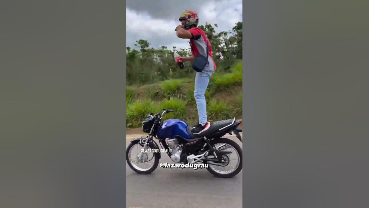 Lázaro Du grau andando em pé na moto e tomando uma coca cola