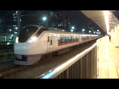 夜の高輪ゲートウェイ駅の黄色いライトを車体に受けながら通過していく上野東京ライン常磐線下り特急ひたちE657系
