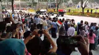 People waving flags and shouting 'Thank you Sir'