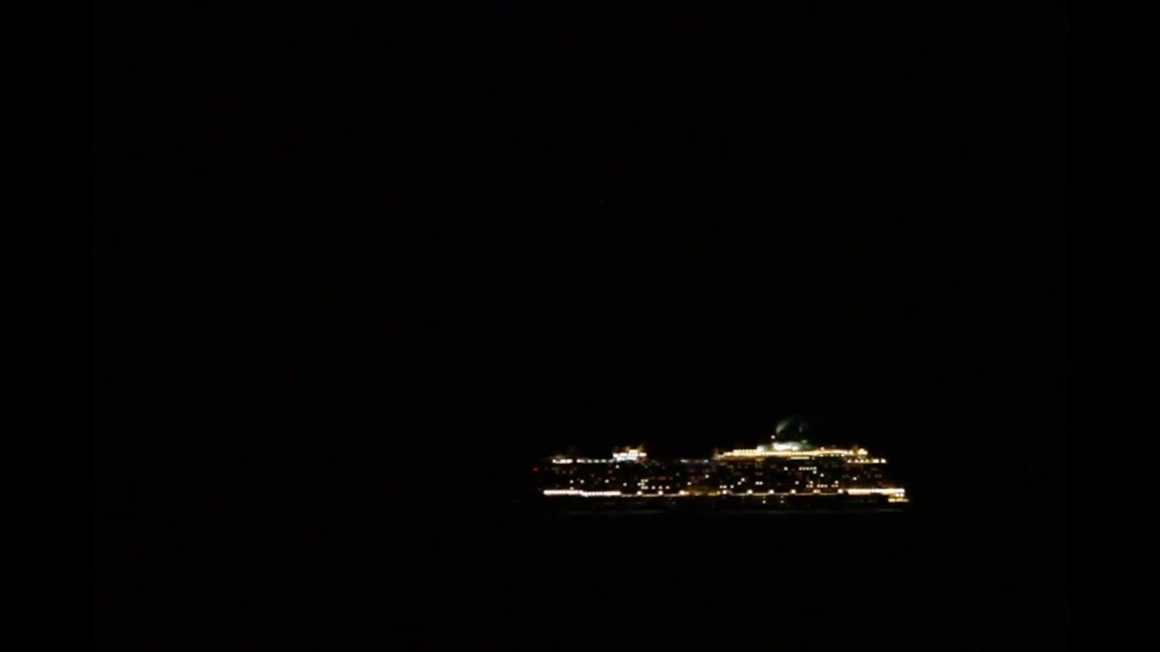 Glowing cruise ship at pitch dark night.