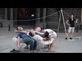 Street performer makes human table from random people