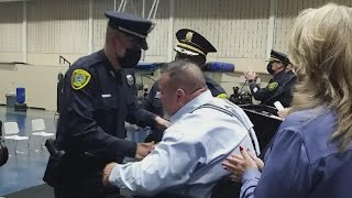 HPD officer left paralyzed by shooting pins own badge on son at Police Academy graduation