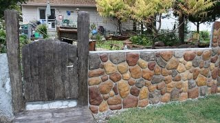 The finishing of the fence project. Shows the installation of a faux bois gate and entryway, finishing the top of the fence, making grout 