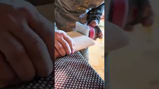 Using an electric orbital sander machine to smooth the curved edges of a wooden board surface