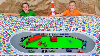 Vlad ve Niki oyuncak arabalarla oynuyor ve Yarış Pisti'ni inşa ediyor Resimi
