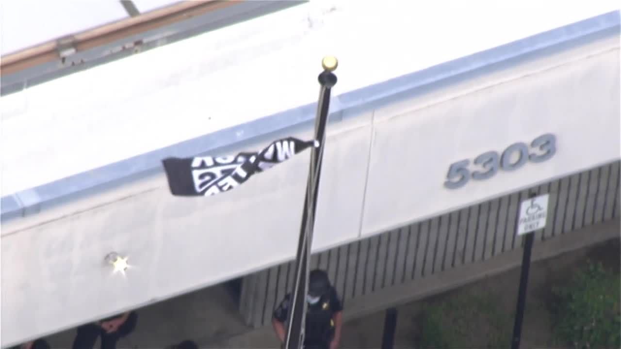 Protesters raise Black Lives Matter flag at police station 