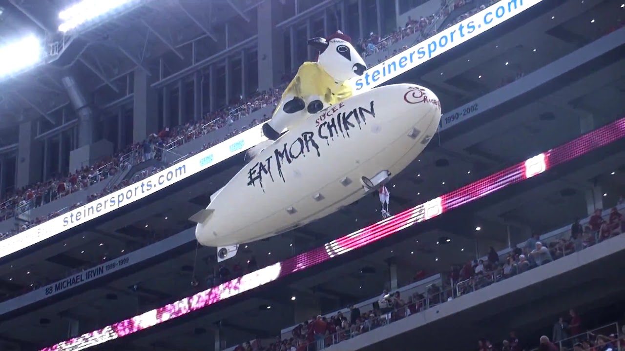 Moo Force One Chick Fil A Blimp flying high over the crowd in the
