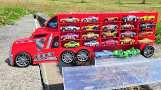 A big red truck runs around the meadow looking for a miniature car