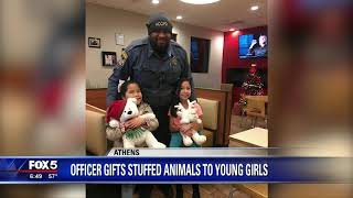 Officer gifts stuffed animals to young girls