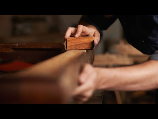 Hombre mano sosteniendo una pulidora de madera