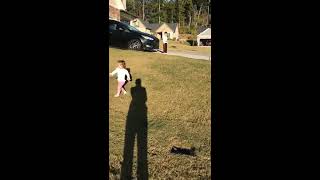 Girl runs in front yard and gets hit on head with ball