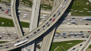 Top down elevated time lapse capturing intense traffic flow on interchange, multi level complex