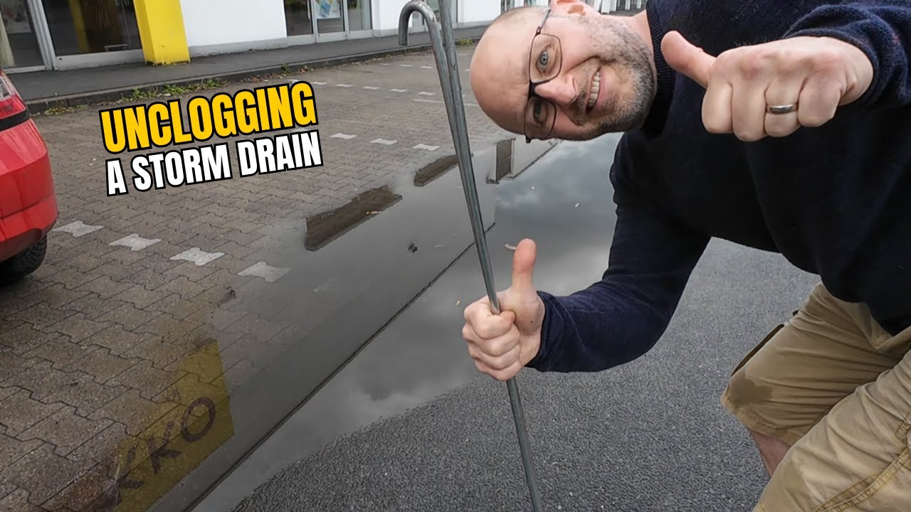 #067-1 Unclogging a storm drain on a parking space after rain in ...