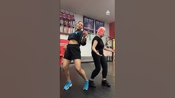 Elderly Woman Performs Zumba Dance With Instructor