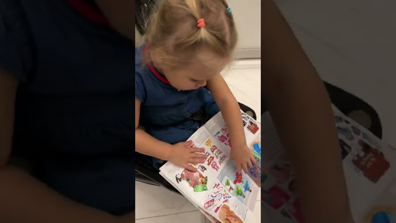 Cute Naomi is reading magazine in the the stroller. Cute Baby video!