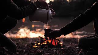 People Pouring A Warm Drink Around A Campfire -1997