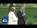 Angela Merkel greets Emmanuel Macron at a distance for meeting