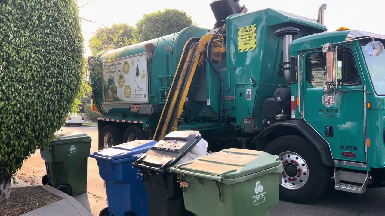 CNG yellow arm peterbilt 520 on trash in the morning