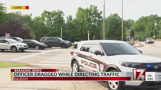 Raleigh police officer drug by car while directing traffic