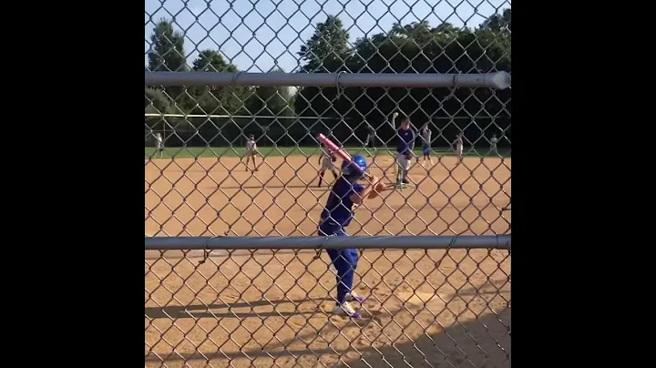 8 year old softball player crushes a line drive into the outfield.