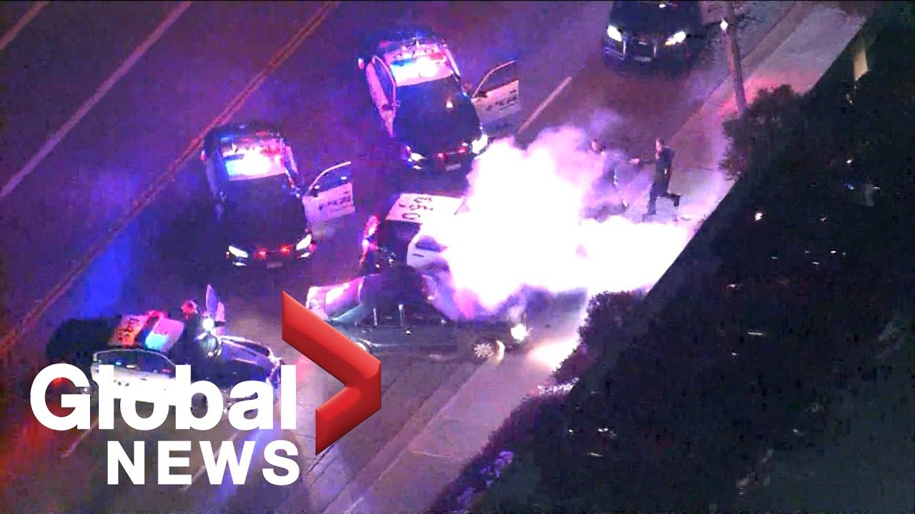 Police chase a vehicle with its hood blown up onto its windshield in
