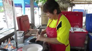 Som Tum by Vendor in Kanchanaburi
Sidewalk chef prepares a simple version of Som Tum with fresh green papaya, green beans, tomato, garlic, chiles, fish sauce, lime juice and palm sugar. Som Tum by Vendor in Kanchanaburi
