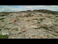 drone shot   two boys running over cliffs in Bohuslän Sweden