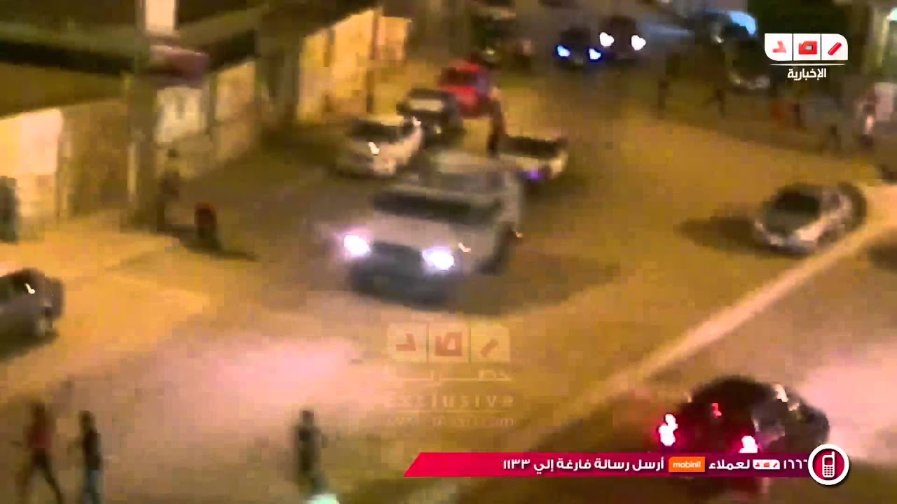 بلطجية المنصورة بجوار سيارة الامن يطاردون السيدات ويقذفوهم بالحجارة في مظاهرات امس