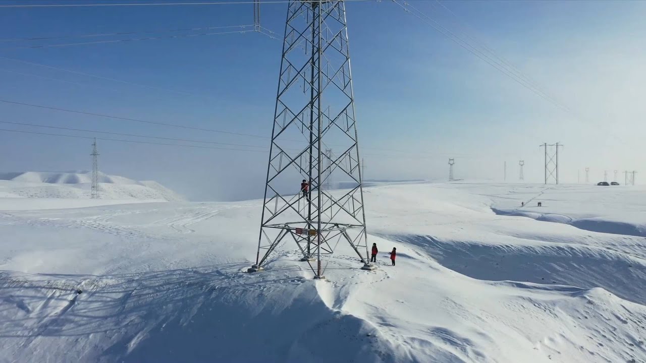 Workers maintain transmission towers in freezing weather in Xinjiang, China
