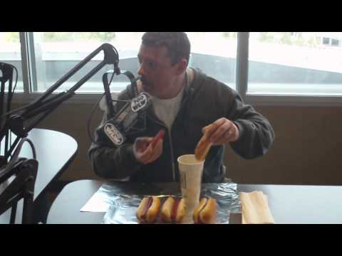 Joey Chestnut teaches Scott Sloan some hotdog eating techniques