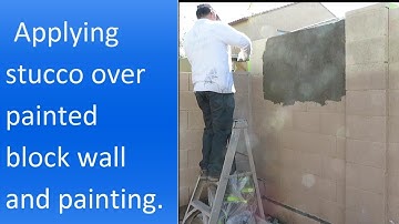 Applying stucco over painted block wall.