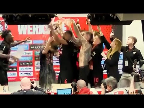 Bayer Leverkusen players shower Xabi Alonso in BEER during Bundesliga title press conference