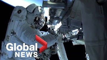 Spacewalking astronauts install solar panels outside ISS
