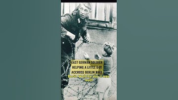 East German soldier helping little boy escape Berlin Wall