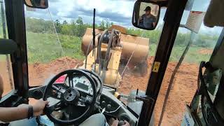 Pá carregadeira.    Fazendo caixa de contenção ou bacia com lombada para tira água da estrada