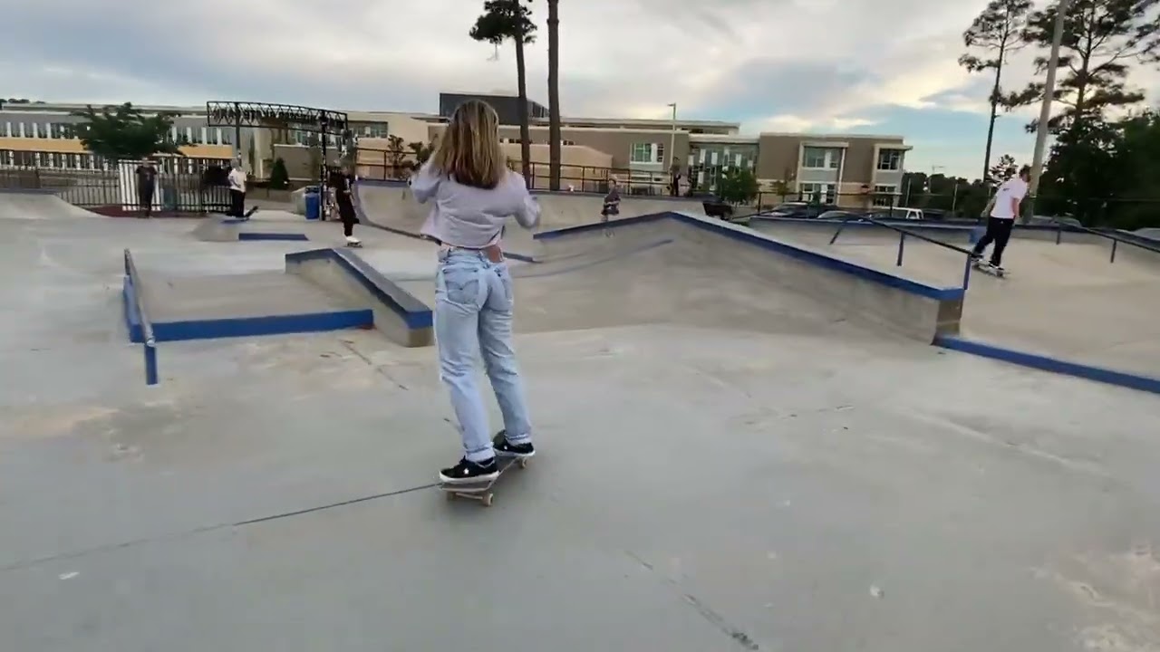 Girl on skateboard attempts shuv-it at skatepark and lands on her back