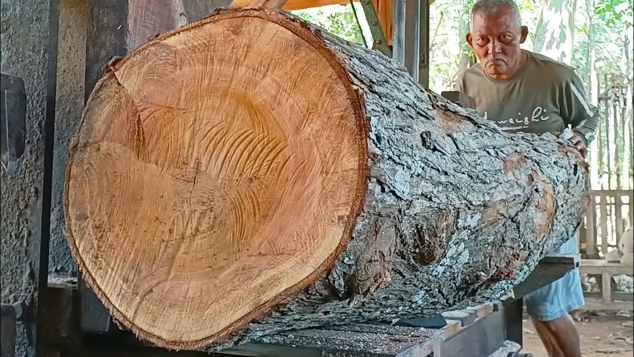 sawing beautiful grained old redwood logs into quality furniture board ...