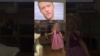 Girl wearing princess costume dances in front of TV and spins around then falls and faceplants