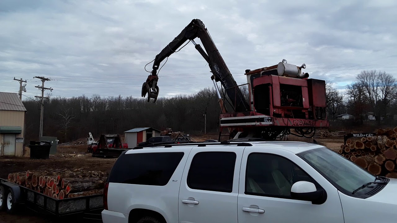 Unloading Cedar Logs at the Giles and Kendall Sawmill in Gainesville, Missouri.