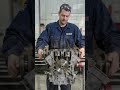 Mechanic rotating an engine by hand after assembly, gears and pistons moving smoothly,